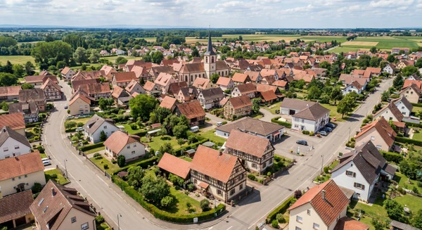 Photographie aérienne ou vue panoramique d'une commune du Bas-Rhin (Fegersheim), montrant des habitations résidentielles typiques de la région avec toitures, rues calmes et environnement périurbain. L'image doit transmettre un sentiment de proximité et d'accessibilité locale, représentative d'une petite commune alsacienne où intervient l'entreprise de rénovation.