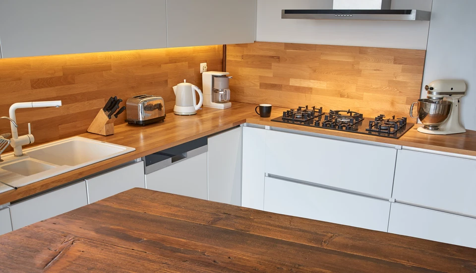 Cuisine moderne avec plan de travail en bois massif lamellé-collé et façades laquées blanches