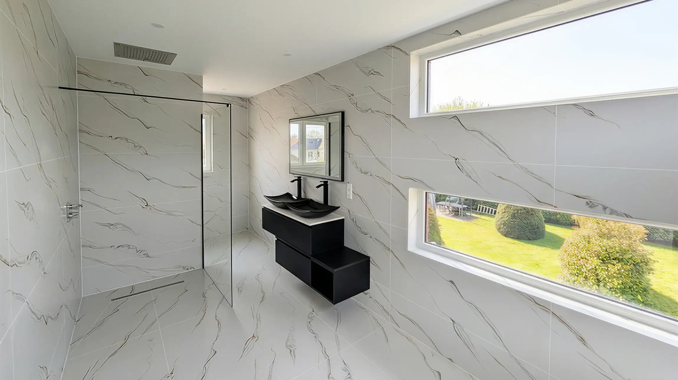 Cuisine moderne ouverte avec îlot central, plan de travail en quartz blanc, mobilier laqué gris anthracite